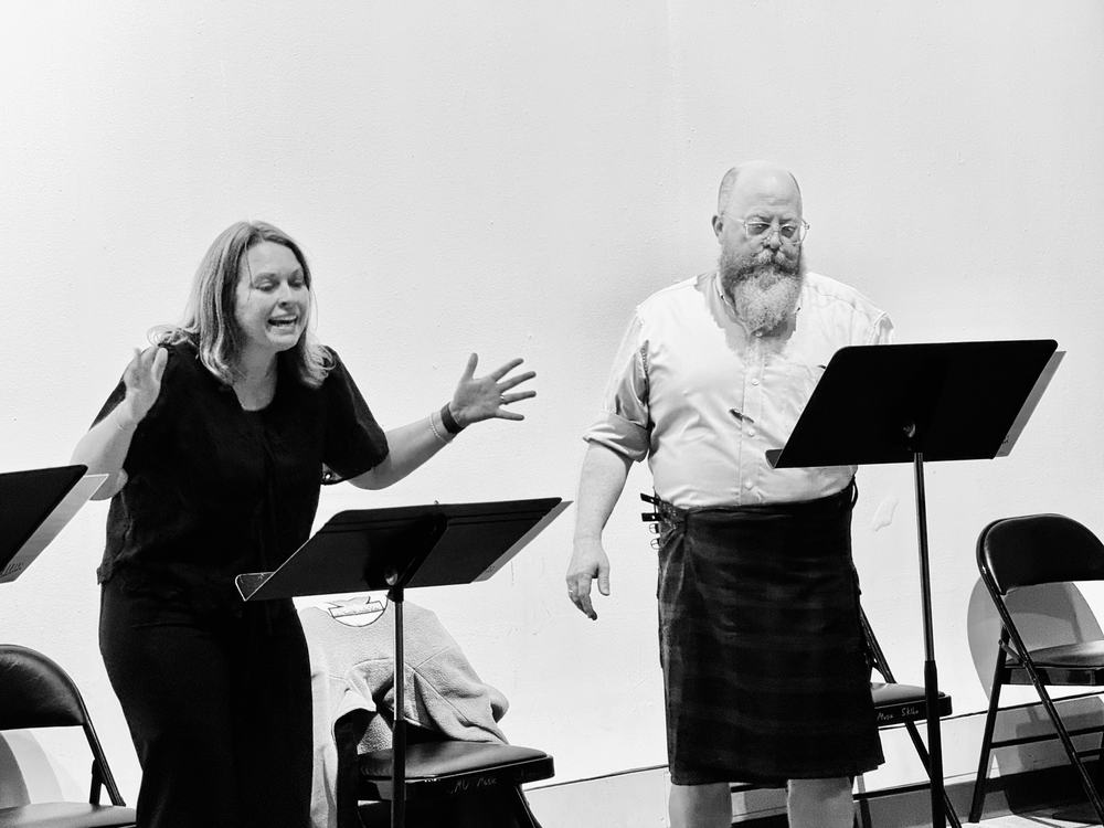 Two actors playing a scene at their stands